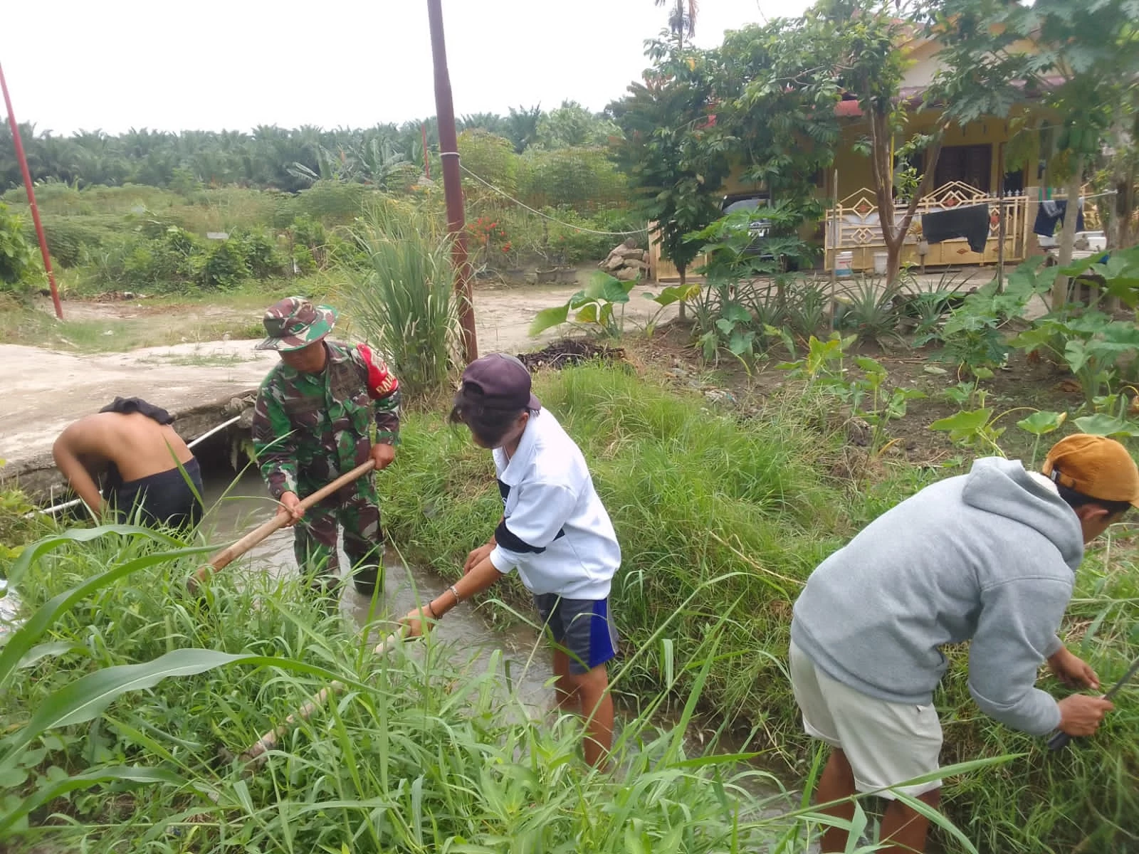 Babinsa Koramil 09/TB Bantu Warga Gotong Royong Bersihkan Saluran Irigasi