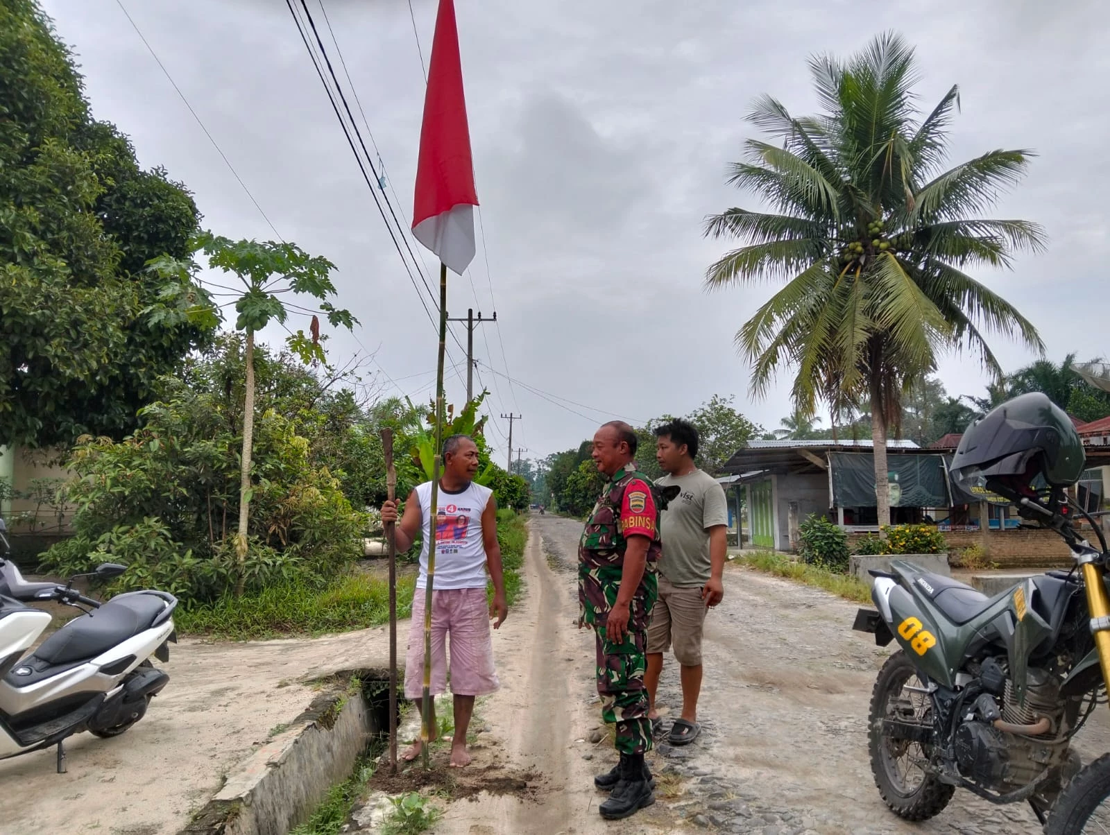 lnovatif, Babinsa Koramil 08/Bangun Bantu Warga Pasang Bendera Merah Putih Di Depan Rumah