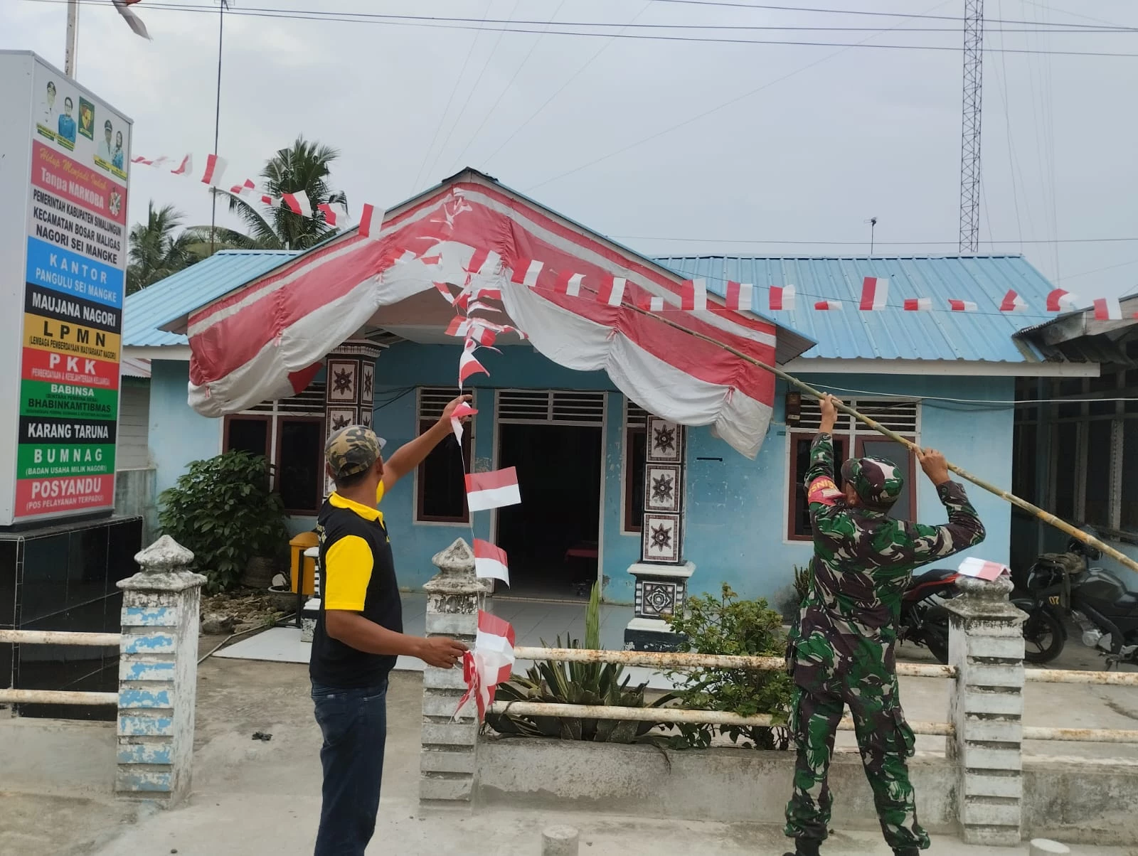 Semarakkan HUT RI Ke-79, Babinsa Bersama Perangkat Nagori Pasang Umbul-Umbul dan Bendera Merah Putih