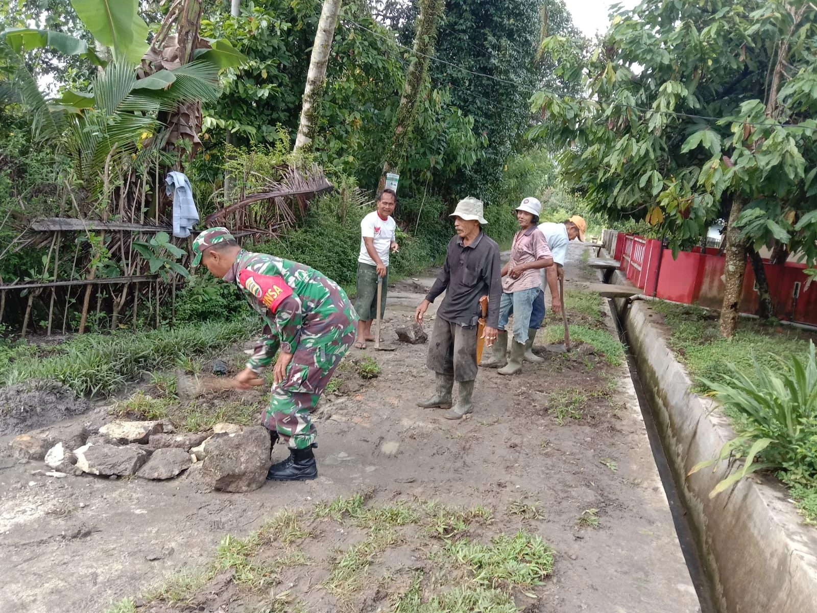 Peduli Keselamatan, Babinsa Bersama Masyarakat Timbun Jalan Berlubang