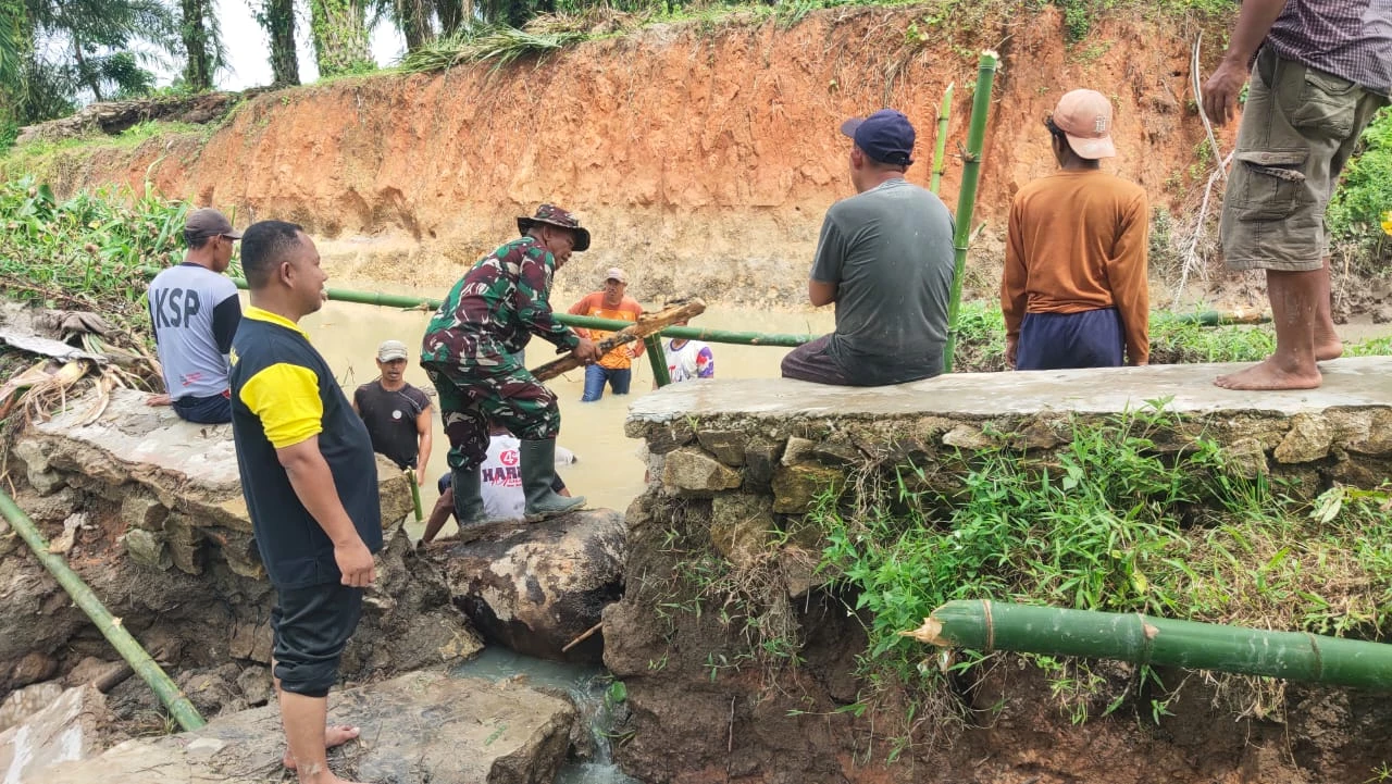 Babinsa Bantu Warga Perbaiki  Tanggul Irigasi Rusak