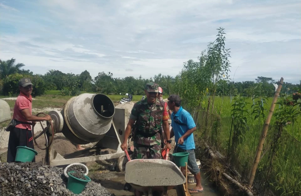 Babinsa ikut serta Bergotong Royong bersama warga  Pengecoran jalan.